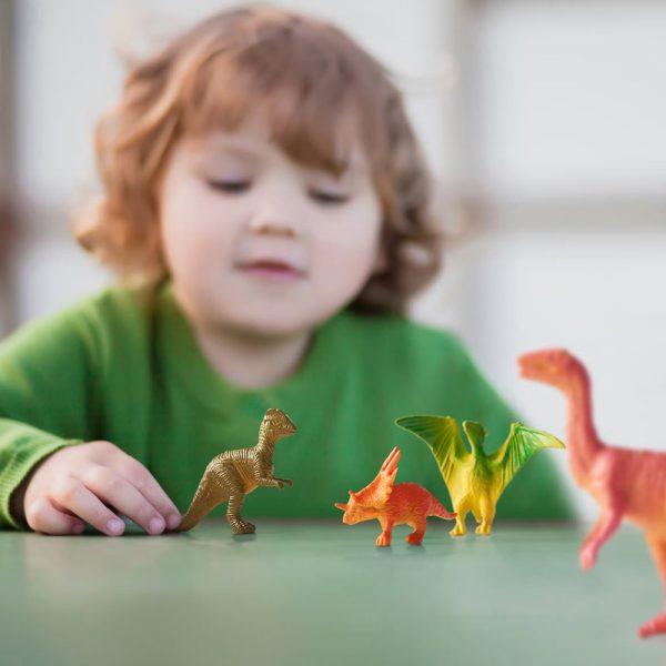 Kind speelt met mini dinosaurussen