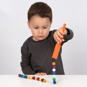 Kind speelt met Magnetische staven met knikkers