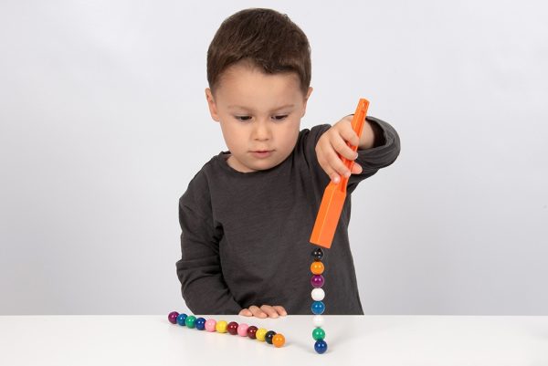 Kind speelt met Magnetische staven met knikkers