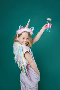 Kind met Petit Boum sensorische fles Eenhoorn